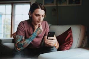 Man with tattoos holding a phone