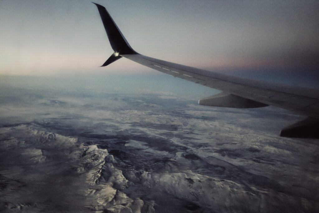 An airplane wing over the mountains